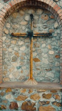 Crucifix of Christian Jesus outdoors in a scene with walls and bricks