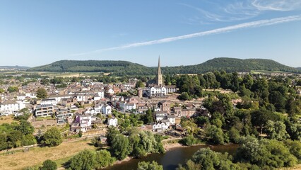 Scenic drone panorama of the historic market town of Ross-on-Wye in Herefordshire, England. The aerial view features St Mary’s Church with its prominent stone spire overlooking the town, the River Wye © ADS Media