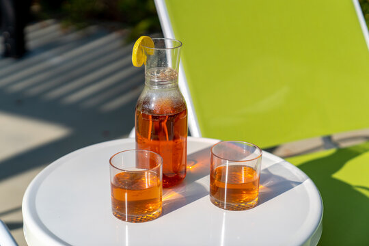 Close-up of iced tea glasses and carafe on white patio table