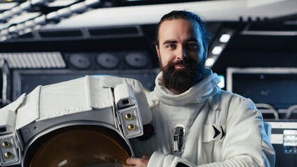Joyous astronaut holds a helmet while performing routine maintenance aboard a starship, navigating an orbital trajectory through deep space after leaving the planet during a planetary mission. © DC Studio