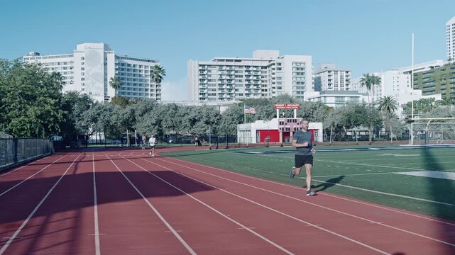 Man running at racetrack outdoor. Runner sprinter with incredible speed. Sport runner completing a marathon. Sport training. Man sportsman running for exercise. Morning run