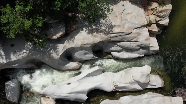 Aerial top-down view of river flowing through rocky canyon