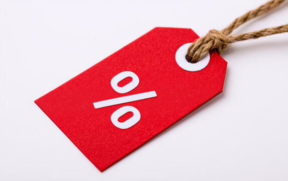 Red Sale Tag with Percent Symbol Indicating Discount or Promotion on a Light Background