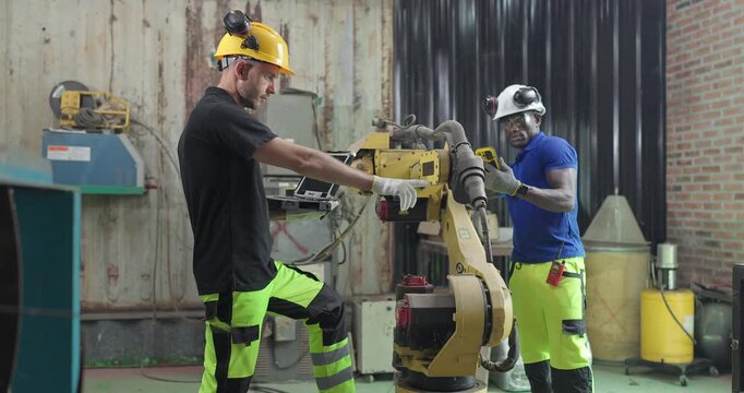 Technicians Troubleshoot Robotic Arm Control System for Automation Maintenance