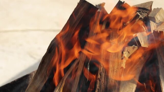 Glowing hot charcoal in barbecue grill pit with open flames close up background texture for bbq cooking and outdoor fire concept
