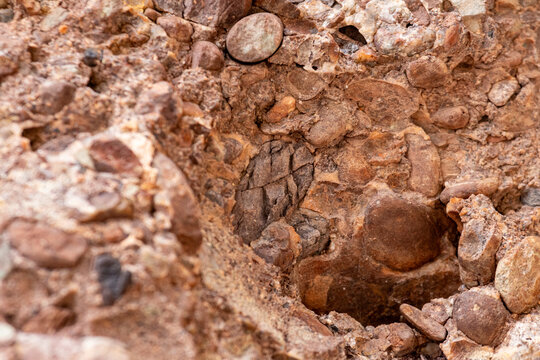 Gaspesie, Quebec, 07 June 2026 : Close-up view of a natural rock formation showing embedded stones and cracked surfaces.