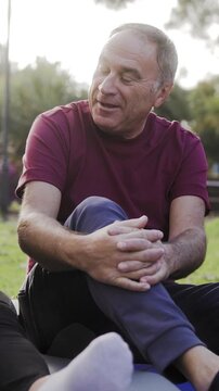 Senior man have fun talking with friends after yoga class outdoor at park city - Elderly community concept - Vertical video