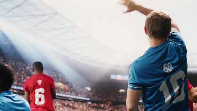 Diverse footballers teammates celebrating winning goal with raised arms, disappointed opposing players beaten on pitch, match day mixed emotions for two teams, cheering for victory.