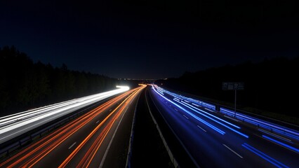 Obraz premium Blue and Orange Car Light Trails on a Highway at Night