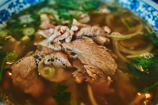 Up close with a bowl of pho - beef, noodles, and herbs in broth