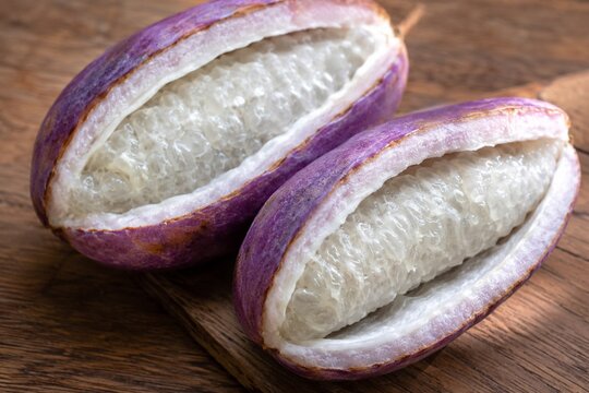 Purple akebi fruit split open showing white translucent pulp