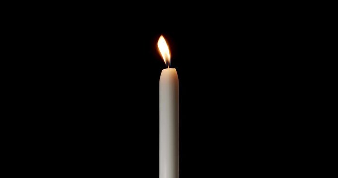 A single white candle burning brightly on a dark background. This isolated paraffin candle creates a peaceful atmosphere. Use this glowing candle for concepts of memory, faith, and hope.