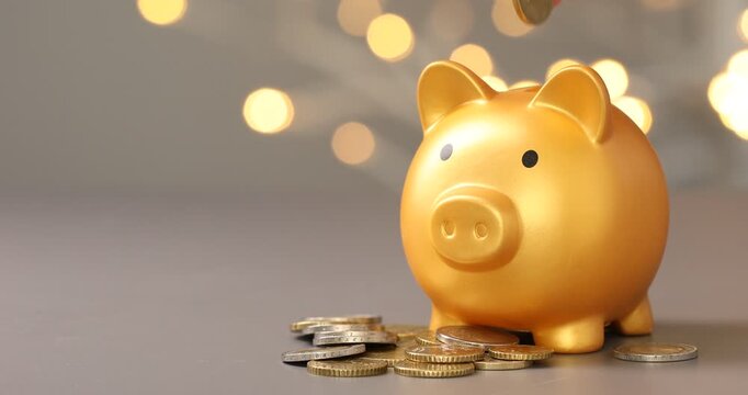 Woman putting coins into piggy bank against grey background with blurred lights, closeup. Bokeh effect