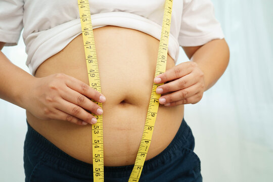 Asian woman with fat belly big size overweight and obesity with measure tape.