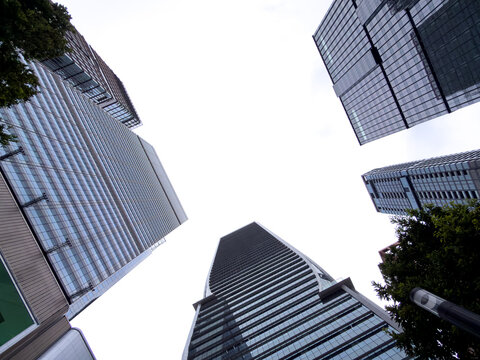 Modern glass building facade with cityscape skyscraper reflection.