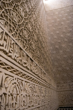Intricate Carved Arabic Calligraphy and Arabesque Reliefs Covering Ancient Wall in Tlemcen