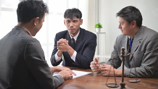 Lawyers discussing case with client in office