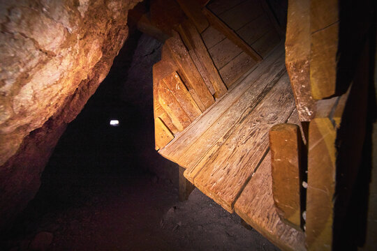 Wooden Support Structure in Historic Mine Shaft with Textured Rock Walls