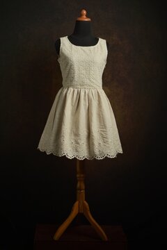 Ivory eyelet dress displayed on a mannequin display