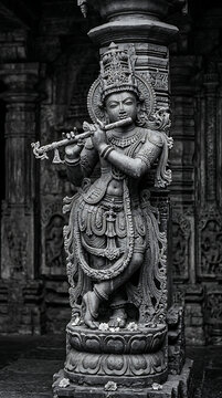 Intricate black and white photograph of a classical Hindu stone sculpture depicting a divine musician playing a flute with