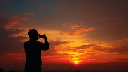 Fototapeta premium Man photographing sunset with mobile phone