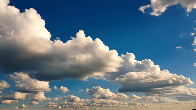 Cumulus clouds drift across a wide expanse of deep blue sky during the golden hour, providing a serene and natural background that evokes a sense of peace, clarity, and limitless atmospheric beauty.