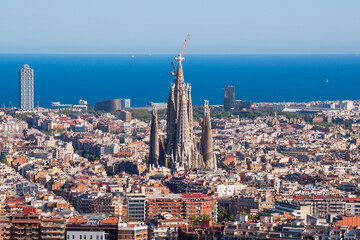 Obraz premium Elevated View of Barcelona City With Famous Sagrada Familia Church and Mediterranean Sea in the Horizon