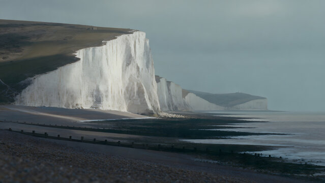 Dover white cliffs and expansive coastline, overcast weather, cinematic landscape.