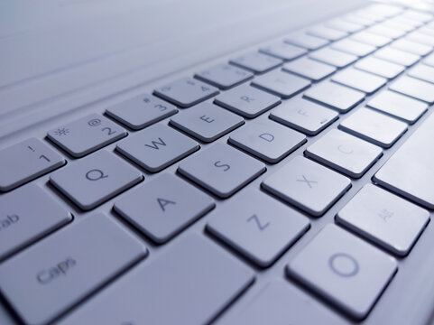 Close-up photo of a modern white computer keyboard, featuring clear QWERTY key details and a sleek design perfect for tech, office, and business concepts.