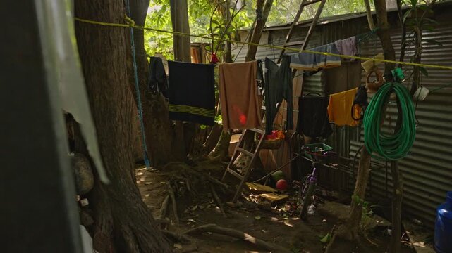 Accumulation of plastic containers, blue jugs, and buckets organized on informal supports in an outdoor utility area.