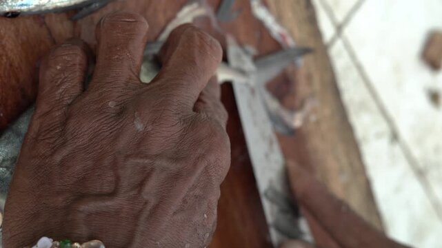 Traditional fish cleaning and filleting process by hand on a wooden table