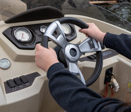 Person steering a modern pontoon boat