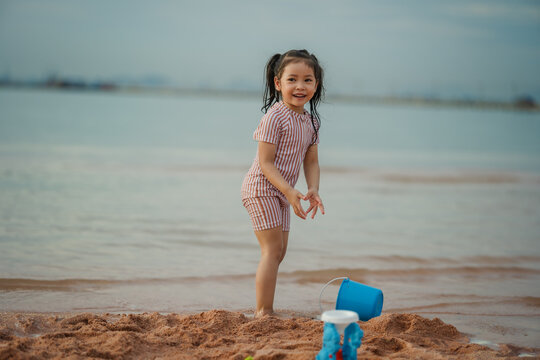 happy preschool child girl playing on sea beach in Pattaya, Thailand