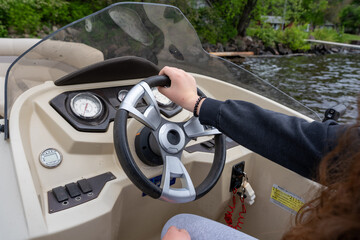 Person steering a modern pontoon boat © Olha Semeniv