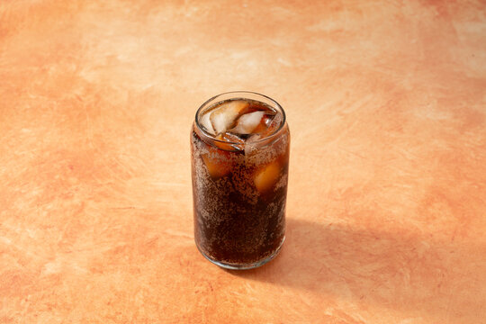 A view of a root beer cola drink, in a can shaped glass.