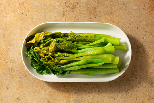 A top down view of a plate of blanched yu choi.