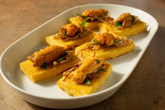 A view of a plate of uni canapes.