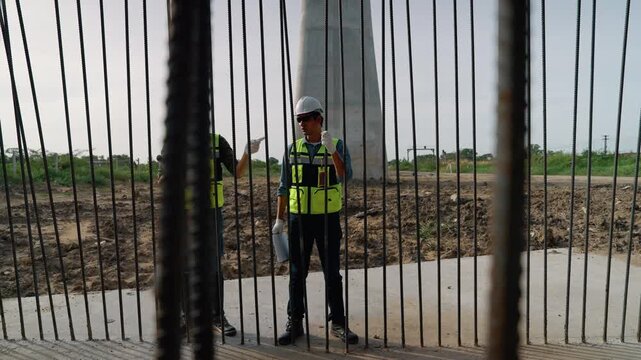 Construction engineers examining reinforced steel bars and concrete foundation during structural inspection at a large infrastructure development project.
