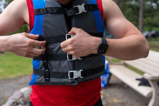 Person buckling up a life jacket for safety