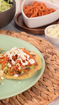 Homemade tostadas de tinga close-up served on a green plate