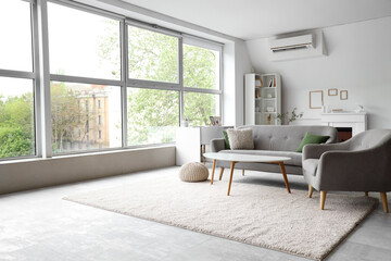Obraz premium Interior of light living room with grey sofa, armchair and coffee table