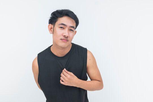 A young Southeast Asian man in a black athletic tank top holds his shirt while looking directly at the camera in a isolated white background.