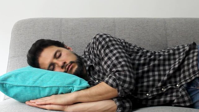 Detailed view of a latin man taking a deeply nap over a grey couch