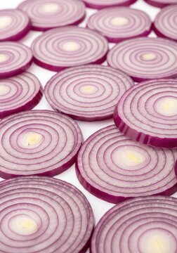 Vibrant red onion slices are neatly arranged in a mesmerizing pattern, showcasing their purple concentric rings and crisp, fresh texture, fresh, kitchen, purple