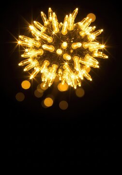 Radiant golden string lights glow intensely against a solid black background, creating a luxurious festive aesthetic with blurred bokeh effects, warm, shine, decorative