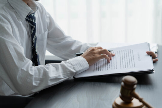 Lawyer reading legal document in office room