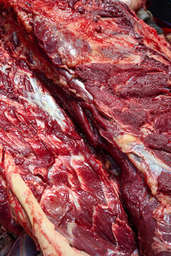Fresh raw beef cuts with bone and muscle texture at a traditional meat market