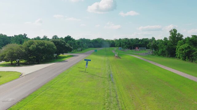 Interstate 10 West truck center highway road signs are captured from an aerial perspective. This drone view shows the directional signage standing on a grassy roadside in Louisiana.