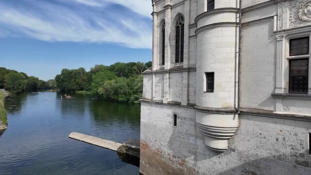 Slow motion video showcasing the elegant exterior of Chateau de Chenonceau spanning the Cher River, highlighting its Renaissance architecture and iconic riverside setting in the Loire Valley, France