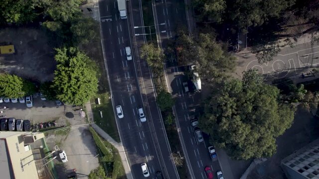 Drone going up revealing traffic in a two ways big avenue
